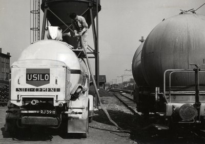 169556 Afbeelding van het overladen van cement van een silowagen van de N.S. naar een vrachtauto van Usilo op de laad- ...